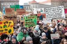 Junge Menschen demonstrieren mit Schilden und Plakaten für mehr Klimaschutz