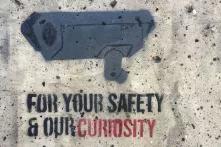 Graffiti mit dem Bild einer Überwachungskamera und dem Text: "For your Safety and our Curiosity".