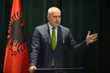 Ed Rama, Premierminister von Albanien vor einem Rednerpult, dahinter die Fahne Albaniens