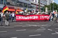 Demonstrierende tragen ein Banner mit der Aufschrift "Coronawahnsin stoppen"