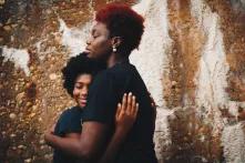 zwei schwarze Frauen nehmen sich in die Arme
