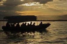 Menschen sitzen im Sonnenuntergang in einem Boot