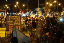 Guatemala: Feiernde Menschenmassen auf der Straße mit Plakaten und zahlreichen guatemaltekischenFlaggen