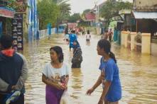 Mehrere Menschen laufen auf einer überfluteten Straße