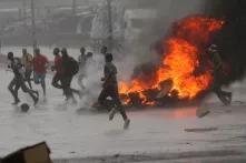 People run at a protest as barricades burn during rainfall in Harare, Zimbabwe January 14