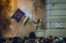 Protesters are waving an EU and a Hungarian flag