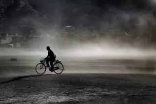 Ein Mann fährt mit seinem Fahrrad auf einer Straße.