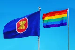 Die ASEAN-Flagge und die Regenbogenfahne vor blauem Himmel